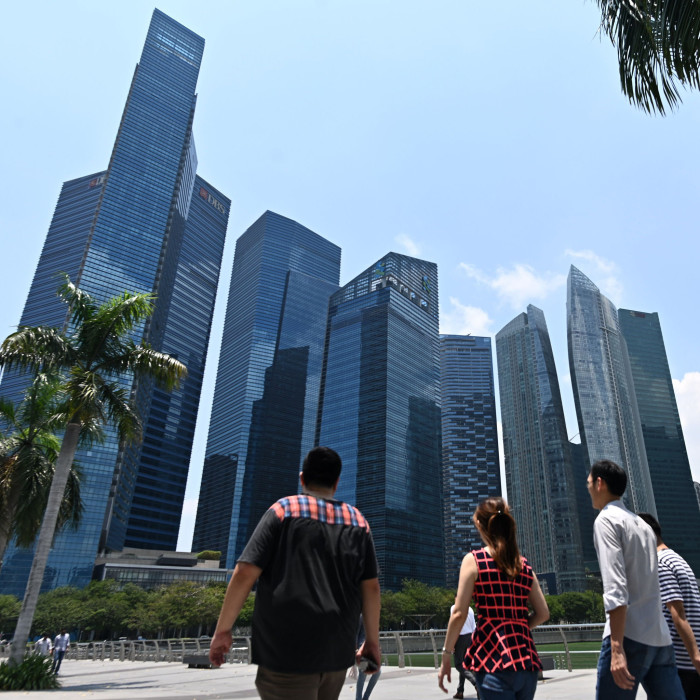 People walk along a promenade with a view of Marina Bay financial centre in Singapore on March 8, 2019. (Photo by Roslan RAHMAN / AFP) (Photo credit should read ROSLAN RAHMAN/AFP via Getty Images)