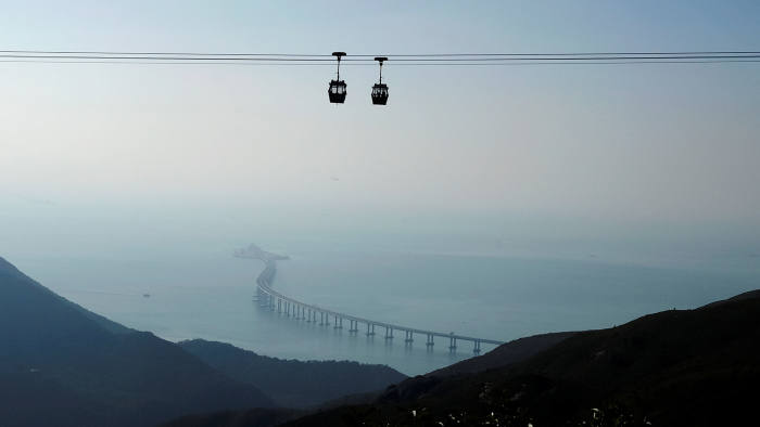 Cable cars move in front of the Hong Kong-Zhuhai-Macau bridge off Lantau island in Hong Kong, China October 21, 2018, before its opening ceremony on October 23, 2018. Picture taken October 21, 2018. REUTERS/Bobby Yip - RC1E19B3D8C0