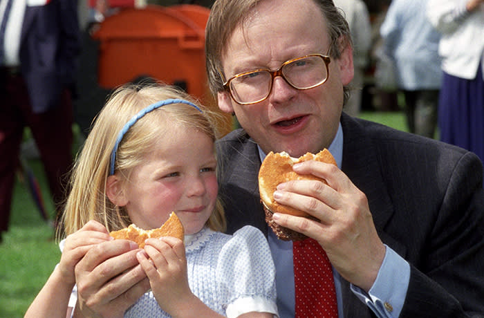 Agriculture minister John Gummer with his 4 year old daughter Cordelia, tuck into a beefburger on a visit to the East Coast Boat Show in Ipswich. The possilbe danger of the BSE disease in British beef was scuppered by the minister. * in an attempt to calm public fears when the beef scare first broke in 1990. Mr Gummer, now Environment Secretary snapped angrily at James Naughtie, presenter of Radio 4's Today programme, when he asked if Mr Gummer now regretted posing for the picture. *25/10/2000 Mr Gummer and other senior members of the Thatcher and Major administrations are bracing themselves for harsh criticism of their handling of the BSE crisis, as the Government publishes the long-awaited results of the inquiry into Britain's biggest public health disaster. Lord Phillips' report, to be published Thursday October 26 2000 is expected to condemn the former Tory government's slow reaction to the crisis and ministers' refusal to accept that humans might be made ill by eating beef from infected cows. 26/10/00: Mr Gummer and other senior members of the Thatcher and Major administrations are bracing themselves for harsh criticism of their handling of the BSE crisis, as the Government publishes the long-awaited results of the inquiry into Britain's biggest public health disaster. Lord Phillips' report, published Thursday October 26 2000, is expected to condemn the former Tory government's slow reaction to the crisis and ministers' refusal to accept that humans might be made ill by eating beef from infected cows.