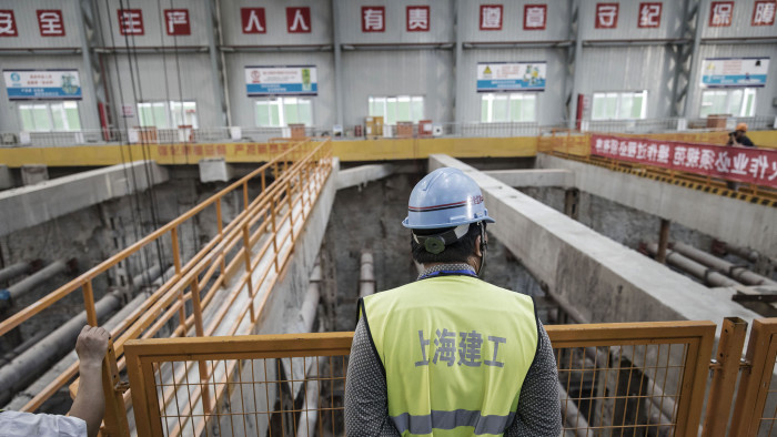 A worker stands overlooking an open pit at a construction site for Line 14 of the Shanghai Metro system in Shanghai, China, on Tuesday, July 11, 2017. The world’s second-largest economy is forecast to slow from the first quarter, when it posted the first back-to-back quarterly acceleration in seven years, though it is still on track to remain above the leadership’s growth target of at least 6.5 percent. Photographer: Qilai Shen/Bloomberg