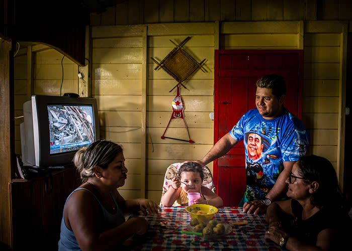 Anna Eloá, 2 years old, is seen having a meal with her parents Francisca Sílvia de Queiroz, 28, and Edeney da Costa Nascimento, 28, and her grandmother Suely da Costa Nascimento, 51 (lower right corner), in their home in São Sebastião do Curari village, in the countryside of Careiro da Várzea city (in Amazonas state, North of Brazil, on January 10th, 2018). She used to be fed with anything, speacially bread. But after her family started taking her for a treatment with a nutritionist, they have been very aware of what she eats: fruits, toast and low sugar drinks. Anna lost two kg and wheighs 20kg now. Children obesity has already been considered pandemic. The condition affects children's development. Photo: FINANCIAL TIMES / RAPHAEL ALVES