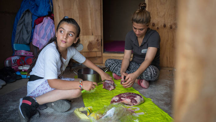 An Iraqi-Kurdish family prepares dinner in the Grande-Synthe camp
