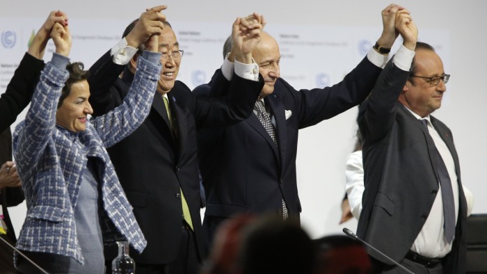 Foreign Affairs Minister and President-designate of COP21 Laurent Fabius (C), raises hands with Secretary General of the United Nations Ban Ki Moon (2-L) and France's President Francois Hollande (R) after adoption of a historic global warming pact at the COP21 Climate Conference in Le Bourget, north of Paris, on December 12, 2015. Envoys from 195 nations on December 12 adopted to cheers and tears a historic accord to stop global warming, which threatens humanity with rising seas and worsening droughts, floods and storms. AFP PHOTO / FRANCOIS GUILLOT / AFP / FRANCOIS GUILLOT        (Photo credit should read FRANCOIS GUILLOT/AFP/Getty Images)