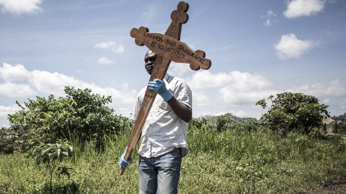 Funeral of Sister-in-law of Hussein Wabuzi - A family member of a deceased Ebola victim carries the cross before the safe burial starts on July 14, 2019 in Beni.