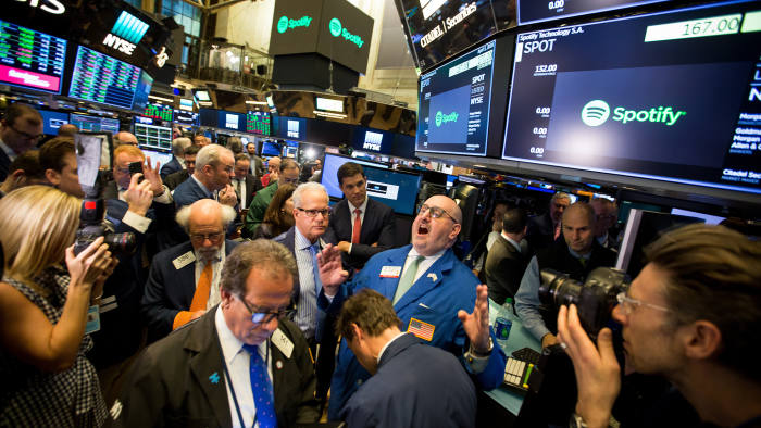 Traders work during the first day of trading for Spotify Technology SA on the floor of the New York Stock Exchange (NYSE) in New York, U.S., on Tuesday, April 3, 2018. Spotify shares climbed in the minutes after it began trading through a direct listing. The company skipped the traditional initial public offering process in favor of a route rarely taken by large, established companies. Photographer: Michael Nagle/Bloomberg