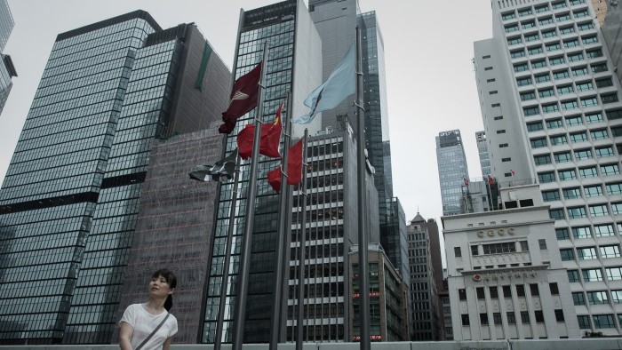 A woman walks past high rise buildings in the financial district of Hong Kong on May 22, 2015. Hong Kong and Shanghai shares rallied on May 22 on hopes for further Chinese stimulus after another indicator suggested the mainland economy is still struggling. AFP PHOTO / Philippe Lopez (Photo credit should read PHILIPPE LOPEZ/AFP/Getty Images)