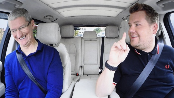 Tim Cook, chief executive officer of Apple Inc., left, is seen on screen smiling in a car with comedian James Corden during an event in San Francisco, California, U.S., on Wednesday, Sept. 7, 2016. Apple Inc. Gadget enthusiasts will be watching with great interest as Apple Inc. is expected to unveil both a new watch and iPhone 7, as well as improvements to the iOS 10 operating system. Photographer: David Paul Morris/Bloomberg