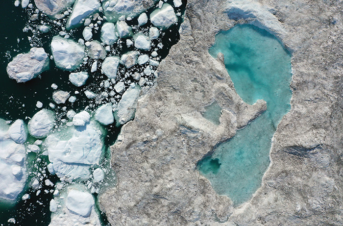 ILULISSAT, GREENLAND - JULY 30: In this aerial view melting ice forms a lake on free-floating ice jammed into the Ilulissat Icefjord during unseasonably warm weather on July 30, 2019 near Ilulissat, Greenland. The Sahara heat wave that recently sent temperatures to record levels in parts of Europe is arriving in Greenland. Climate change is having a profound effect in Greenland, where over the last several decades summers have become longer and the rate that glaciers and the Greenland ice cap are retreating has accelerated. (Photo by Sean Gallup/Getty Images)