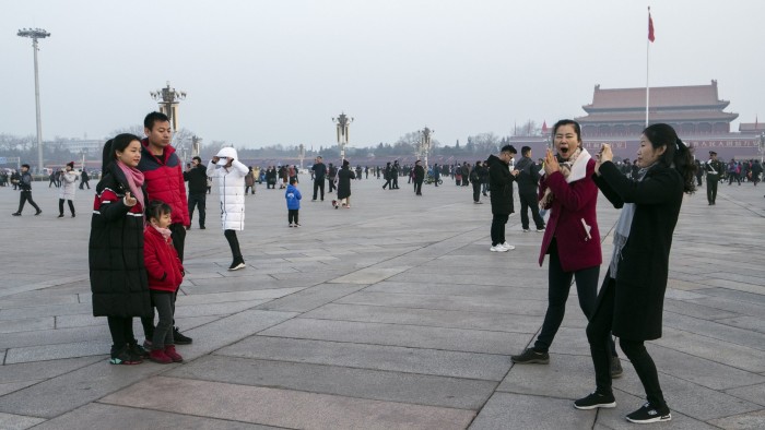 A family poses for photographs at Tiananmen Square in Beijing, China, on Monday, March 4, 2019. National People's Congress spokesman Zhang Yesui said at a briefing on Monday that China would need to increase its military spending to protect itself and that it doesn't pose a threat to other countries. Photographer: Giulia Marchi/Bloomberg