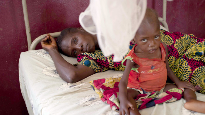 A mother and her child, who is suffering from malnutrition, share a bed at a paediatrics hospital in Bangui, Central African Republic, February 25, 2014. REUTERS/Camille Lepage (CENTRAL AFRICAN REPUBLIC - Tags: POLITICS CIVIL UNREST HEALTH) - RTR3FPTP