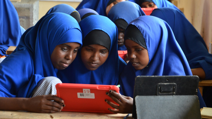 Girl students using tablets pre-loaded with educational software at their Instant Network Schools (INS) classroom in Juba primary school, Dadaab. ; Juba Primary School is one of 32 primary schools located in Dagahaley camp one of the four camps in Dadaab, Kenya. From the 3,181 refugee students study in the school, 610 of them are girls. There are 30 refugee teachers working in the school. In total this year over 50,000 children are enrolled in primary schools in Dadaab camps. The four camps of Dadaab have a total of 32 pre-school centers, 32 primary schools, 7 secondary schools, 18 primary accelerated learning centers, 3 secondary accelerated learning centers, 4 vocational learning centers commonly known as Youth Education Packs, three adult literacy centres, and three libraries. From the total 120,959 school-going age children in Dadaab camps which constitute half of the total population, 70,405 of them are enrolled in schools. Juba Primary School also has an Instant Network School (INS) classroom which is a solar powered classroom with tablets where refugee children and teachers can access digital educational content and the internet over Safaricom’s mobile network. The Instant Network School (INS) program was launched in Dadaab camps in October 2014 by the Vodafone Foundation and UNHCR, the UN Refugee Agency with support from other private donors. INS aims to improve access to quality education for displaced children in refugee camps, through the use of technology and connectivity, alongside teacher training and capacity building support. The program is currently operational in 13 centres including six primary schools, three secondary schools and four vocational training centres in the four camps of Dadaab. These centres which are managed by trained teachers, are currently benefiting over 14,000 refugees in Dadaab. Each Instant Classroom is equipped with a laptop, 25 tablets pre-loaded with educational software, a projector, a speaker and a hotspot inter