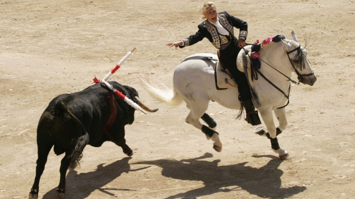 NIMES, FRANCE - MAY 15: Marie-Sara Bourseiller fights a bull from horse-back during the Feria of Pentecost May 15, 2005 in Nimes, France. The feria involves bull-running and bull fights as well as feasting. Nimes is famous for its Iberian influences as well as having some of the best surviving Roman architecture in the world. (Photo by Pascal Parrot/Getty Images)