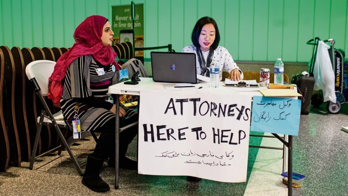 Volunteer translator Nour Our (L) and volunteer attorney Kat Choi (R) sit in the arrivals area during a protest of the executive order by US President Donald Trump, banning immigrants from seven majority-Muslim countries at Los Angeles International Airport in Los Angeles, California, February 4, 2017. / AFP / Kyle Grillot (Photo credit should read KYLE GRILLOT/AFP/Getty Images)