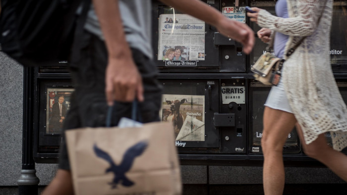 Pedestians pass copies of the Chicago Tribune for sale in a newspaper vending machine, or &quot;honor box&quot; in Chicago, Illinois, U.S., on Friday, Aug. 7, 2015. Tribune Media Co. is scheduled to report second-quarter earnings results before the opening of U.S. financial markets on August 13. Photographer: Christopher Dilts/Bloomberg