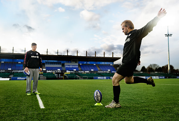 Owen Farrell teaches Carl Wilkinson how to slot a rugby ball through the posts