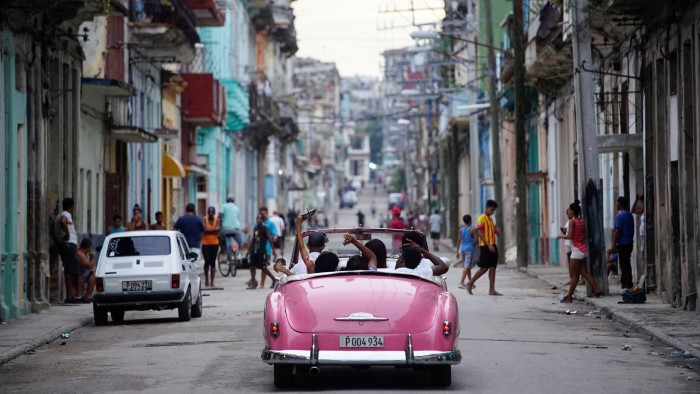 Tourists ride a vintage car in Havana, Cuba, June 11, 2018. REUTERS/Alexandre Meneghini - RC1B63C6C2B0