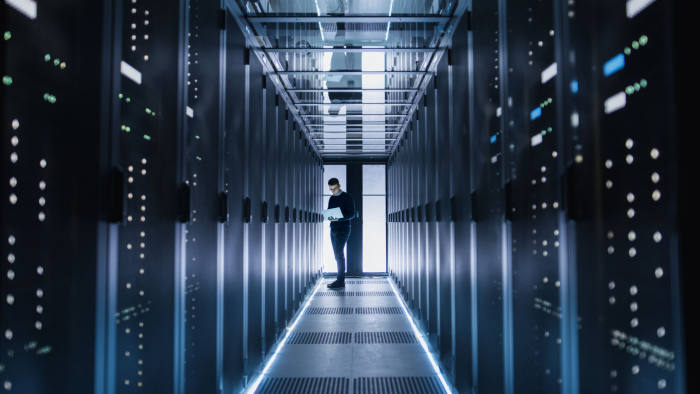 Male IT Engineer Works on a Laptop in a Big Data Center. Rows of Rack Servers are Seen.; Shutterstock ID 662878942; Department: -; Job/Project: -; Employee Name: -