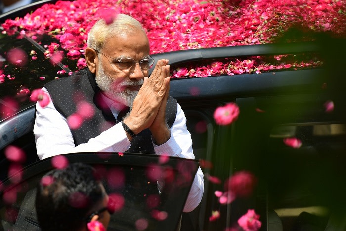 Indian Prime Minister and leader of the Bharatiya Janata Party (BJP) Narendra Modi gestures to supporters as he arrives to file his election nomination papers at district collectorate office, in Varanasi on April 26, 2019. (Photo by SANJAY KANOJIA / AFP) (Photo credit should read SANJAY KANOJIA/AFP/Getty Images)