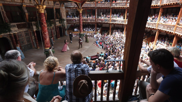 Theatregoers Enjoy The Sunshine During A Performance At The Globe...LONDON, ENGLAND - JULY 16: Audience members watch a production of 'A Midsummer Night's Dream' in Shakespeare's Globe theatre on the Southbank of the River Thames on July 16, 2013 in London, England. The United Kingdom is experiencing a second week of heatwave conditions. . (Photo by Oli Scarff/Getty Images)