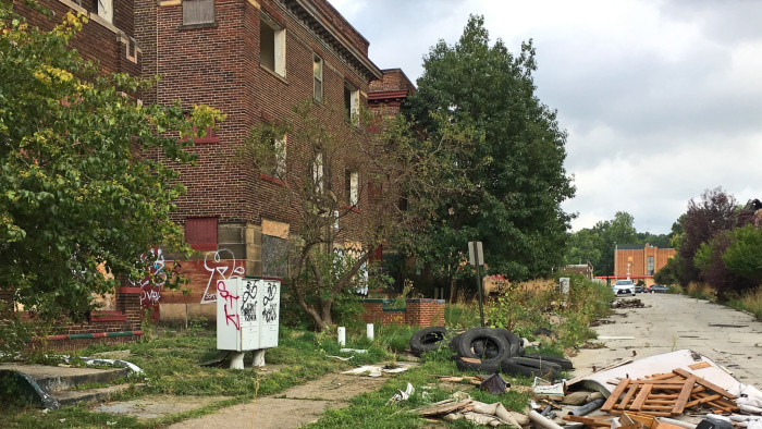 This Aug. 31, 2016, photo shows discarded tires and other refuse piling up on cracked pavement and sidewalks, alongside graffiti-scarred buildings with missing windows in East Cleveland, Ohio. Cleveland and East Cleveland, two of the country's poorest cities, are debating whether to merge, with both cities saying the state of Ohio needs to provide millions to begin fixing East Cleveland's infrastructure and finances. (AP Photo/Mark Gillispie)