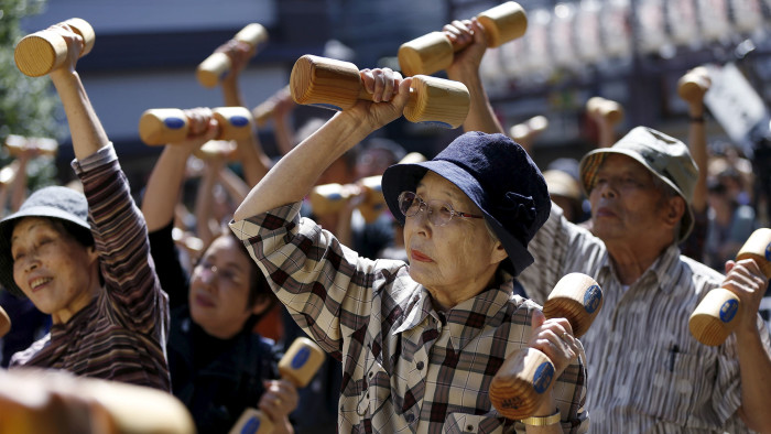 Elderly and middle-age people exercise with wooden dumbbells during a health promotion event to mark Japan's &quot;Respect for the Aged Day&quot; at a temple in Tokyo...Elderly and middle-age people exercise with wooden dumbbells during a health promotion event to mark Japan's &quot;Respect for the Aged Day&quot; at a temple in Tokyo's Sugamo district, an area popular among the Japanese elderly, September 21, 2015. REUTERS/Issei Kato - RTS2362