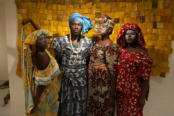 Serge Attukwei Clottey and performers in front of one of his works