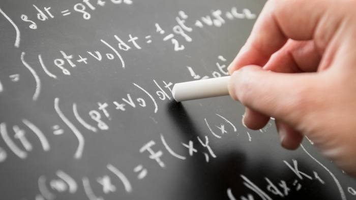 math teacher writing on the blackboard