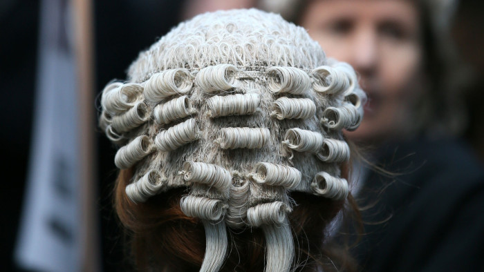 Lawyer Alice Jarratt takes part in a protest outside Southwark Crown Court during a demonstration against cuts to legal aid funding, in London, Monday, Jan. 6, 2014. Hundreds of British lawyers, many dressed in traditional wigs and gowns, have swapped courtrooms for picket lines to protest planned cuts to legal-aid funding. Hearings were disrupted Monday at courts including London’s famous Old Bailey as barristers staged their first-ever national walkout. The British government, which has slashed spending in the name of deficit reduction, plans to cut lawyers’ fees in a bid to reduce the legal aid budget by 220 million pounds ($360 million) by 2019.  (AP Photo/Alastair Grant)