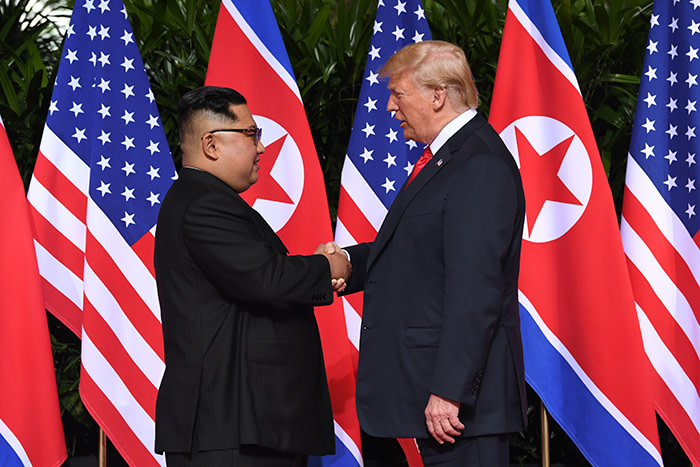 TOPSHOT - North Korea's leader Kim Jong Un (L) shakes hands with US President Donald Trump (R) at the start of their historic US-North Korea summit, at the Capella Hotel on Sentosa island in Singapore on June 12, 2018. - Donald Trump and Kim Jong Un have become on June 12 the first sitting US and North Korean leaders to meet, shake hands and negotiate to end a decades-old nuclear stand-off. (Photo by SAUL LOEB / AFP) (Photo credit should read SAUL LOEB/AFP/Getty Images)