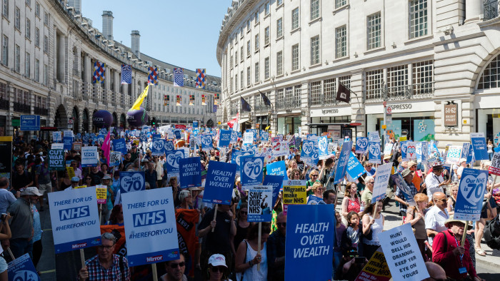 LONDON, UNITED KINGDOM - JUNE 30: Thousands of demonstrators take part in a march followed by a rally outside Downing Street in central London to celebrate the 70th anniversary of the National Health Service. Protesters call for an end to austerity policies which lead to underfunding and staff shortages in the NHS, and demand that it remains publicly owned and accessible to everyone. June 30, 2018 in London, England. (Photo credit should read Wiktor Szymanowicz / Barcroft Media via Getty Images)