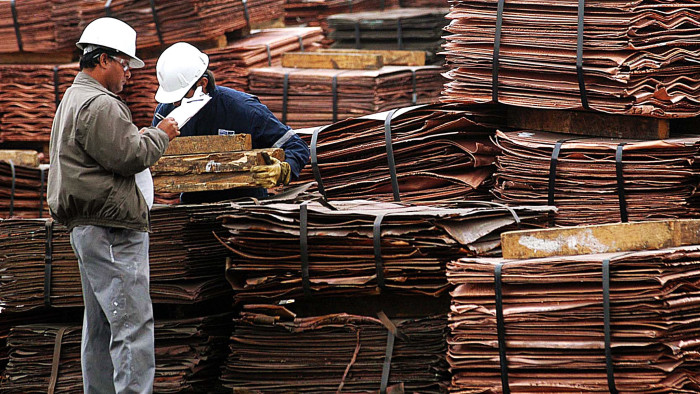 Two workers inspect copper plates that are to be transported in Antofagasta, Chile