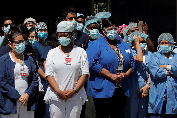 Healthcare workers gather outside Brooklyn Hospital Center in New York. The state has been the epicentre of the disease in the US
