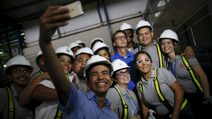 Lorenzo Mendoza, towards the back, in blue shirt, with workers at a Polar distribution centre