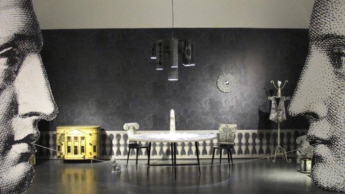 room designed by Fornasetti, wit chairs, table, chandelier, and coat hanger