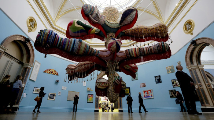 People walk around Portuguese artist Joana Vasconcelos' large scale textile work &quot;Royal Valkyrie&quot; and other works which feature in this year's Summer Exhibition on it's 250th year at the Royal Academy of Arts in London, Tuesday, June 5, 2018. The Summer Exhibition has been held since 1769, with around 1300 works on display this year and most of them available for purchase. It runs from June 12 until August 19. (AP Photo/Matt Dunham)