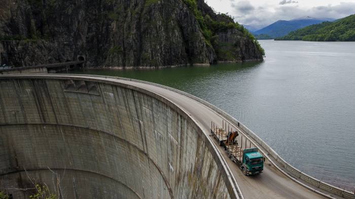 A truck is driven over the dam of Vidraru hydro power plant May 30, 2014. REUTERS/Bogdan Cristel (ROMANIA - Tags: BUSINESS ENERGY TRANSPORT) - GF2EA6212HN01