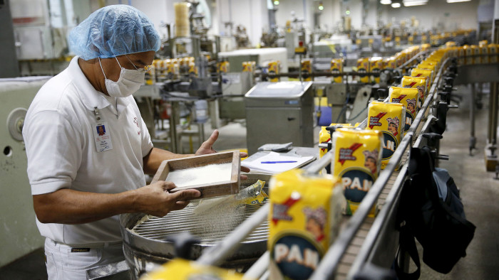 A worker inspects a sample on the production line of PAN corn flour at an industrial complex of food company Empresas Polar in Turmero, in the state of Aragua, Venezuela, October 23, 2015.