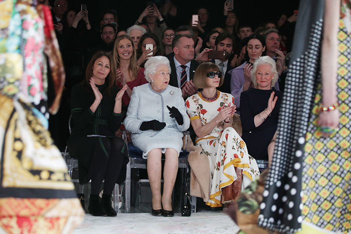Britain's Queen Elizabeth II, accompanied by Chief Executive of the British Fashion Council (BFC), Caroline Rush (L), British-American journalist and editor, Anna Wintour (2R) and royal dressmaker Angela Kelly, views British designer Richard Quinn's runway show before presenting him with the inaugural Queen Elizabeth II Award for British Design, during her visit to London Fashion Week's BFC Show Space in central London on February 20, 2018. / AFP PHOTO / POOL / Yui Mok (Photo credit should read YUI MOK/AFP/Getty Images)