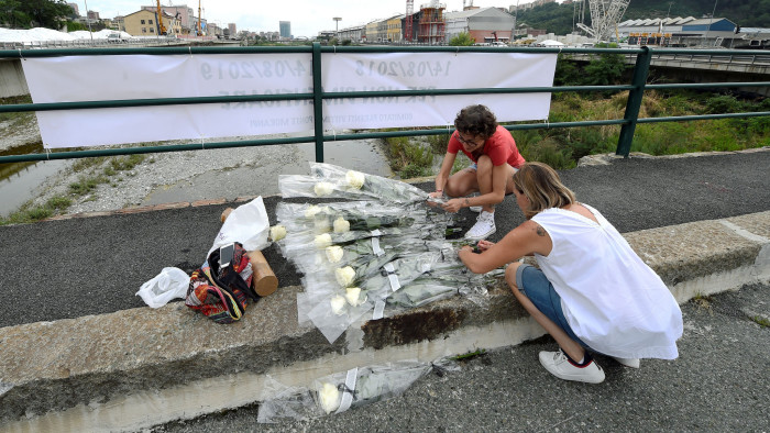 People pay tribute with flowers to bridge collapse victims, marking the first anniversary of Morandi bridge collapse in which 43 people died, in Genoa, Italy, August 13,2019. REUTERS/Massimo Pinca