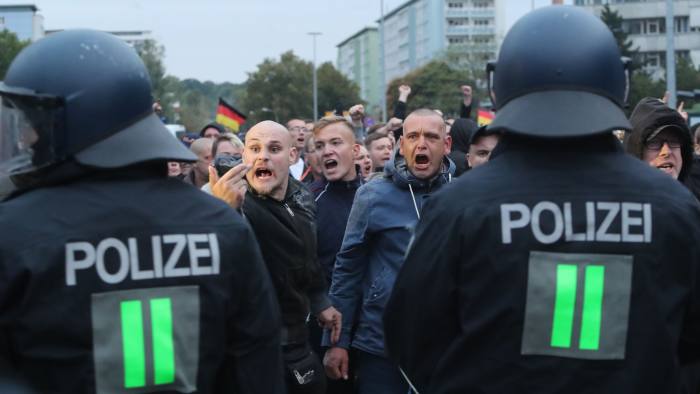 Mandatory Credit: Photo by MARTIN DIVISEK/EPA-EFE/REX/Shutterstock (9843027ck) Right-wing protesters shout behind a row of police men in Chemnitz, Germany, 01 September 2018. Organizations of civil society and right-wing groups called for several demonstrations on the weekend after two refugees from Syria and Iraq were arrested on suspicion of stabbing a 35-year-old man in what police described as a 'scuffle between members of different nationalities' at a city festival in the East German city Chemnitz. Demonstrations after stabbing of a 35-year-old man in Chemnitz, Germany - 01 Sep 2018
