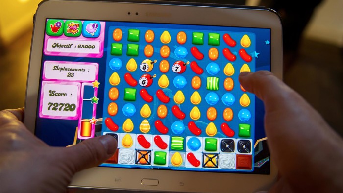 A person plays on his tablet with Candy Crush Saga games developed by British King Digital Entertainment, on March 6, 2014, in Lille, northern France. The game is free, but players can pay for in-app extras to help them pass up through its more than 500 levels. Millions of commuters, teenagers -- even pensioners -- clock in daily to test their skills at the game, which involves lining up tiny pieces of colored sweets to make them vanish from the screen of their computer or mobile phone.