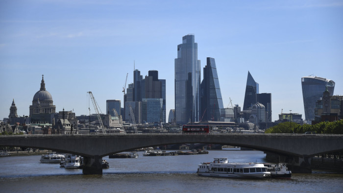 Buses drive across Waterloo Bridge, against the backdrop of the City of London' skyline in London, Monday, May 18, 2020. Britain's Prime Minister Boris Johnson announced last Sunday that people could return to work if they could not work from home. (AP Photo/Alberto Pezzali)