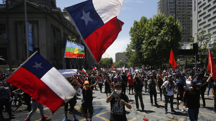 SANTIAGO, CHILE - OCTOBER 23: Demonstrators wave flags of Chile during the sixth day of protest against President Sebastian Piñera on October 23, 2019 in Santiago, Chile. Although President Sebastian Piñera announced yesterday a few measures to improve equality, unions called for a national strike and demonstrations continue as casualties are now 18. Demands behind the protest include issues like health care, pension system, privatization of water, public transport, education, social mobility and corruption. (Photo by Marcelo Hernandez/Getty Images)