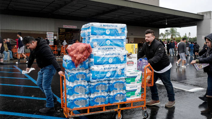 Mandatory Credit: Photo by Ringo Chiu/ZUMA Wire/Shutterstock (10583396u) Shoppers exit a Costco warehouse with carts full of toilet paper, water and other supplies on Saturday, in City of Commerce, California. Coronavirus Outbreak, Los Angeles, USA - 14 Mar 2020