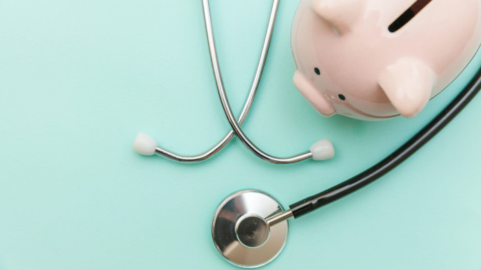 T90YTR Medicine doctor equipment stethoscope or phonendoscope and piggy bank isolated on trendy pastel blue background. Health care financial checkup or savi