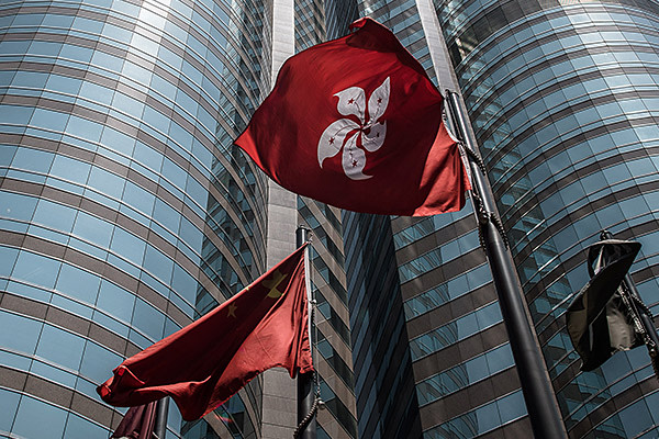 This picture taken on April 16, 2015 shows the Hong Kong flag (centre-R) fluttering next to the Chinese national flag (centre-L) outside the stock exchange building in Hong Kong