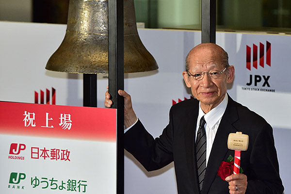 Japan Post Holdings president Taizo Nishimuro rings a bell during the ceremony for the company's listing at the first sector of the Tokyo Stock Exchange on November 4, 2015