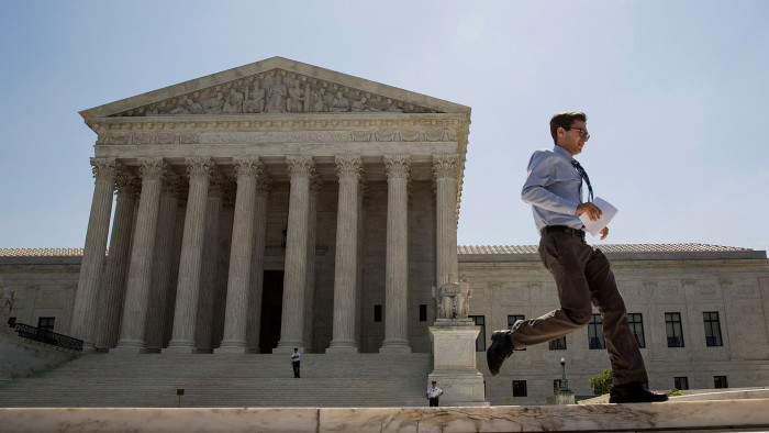 An intern runs an opinion to colleagues in front of the U.S. Supreme Court in Washington, D.C., U.S., on Monday, June 22, 2015.