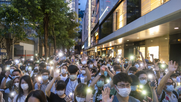 Demonstrators shine lights from smartphones as they march during a protest in the Central district of Hong Kong, China, on Tuesday, June 9, 2020. Hundreds of protesters converged on Hong Kong's Central business district, defying police warnings of unlawful assembly to mark the one-year anniversary of the first major march against since-scrapped legislation allowing extradition to China. Photographer: Justin Chin/Bloomberg
