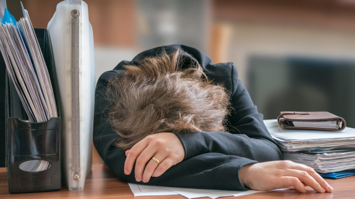 A worker falls asleep at her desk